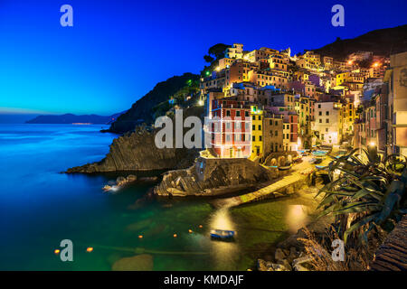 Riomaggiore villaggio sulla scogliera di rocce e mare al tramonto., Seascape in cinque terre, il Parco Nazionale delle Cinque Terre Liguria Italia Europa. Esposizione lunga Foto Stock