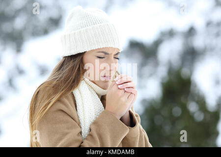 La donna sofferente all'aperto a freddo in una montagna innevata in inverno Foto Stock