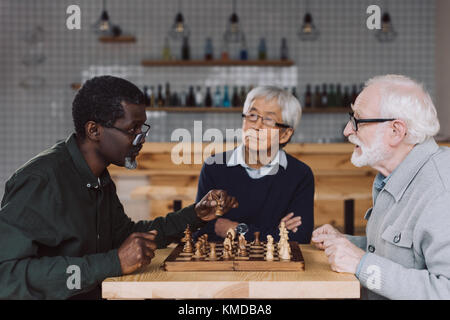 Senior amici giocando a scacchi Foto Stock