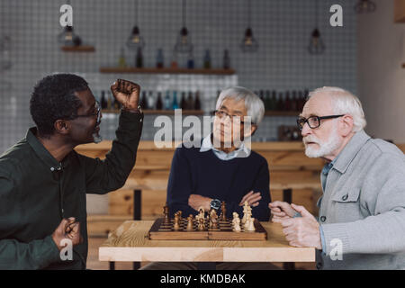 Senior amici giocando a scacchi Foto Stock