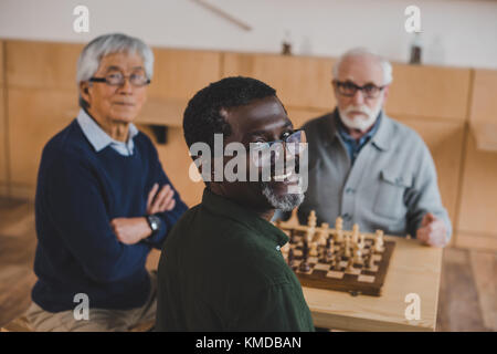 Senior amici giocando a scacchi Foto Stock