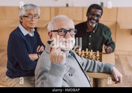 Senior amici giocando a scacchi Foto Stock