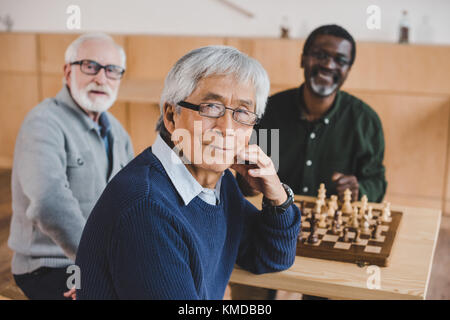 Senior amici giocando a scacchi Foto Stock