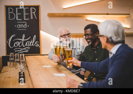 Senior gli amici a bere birra insieme Foto Stock