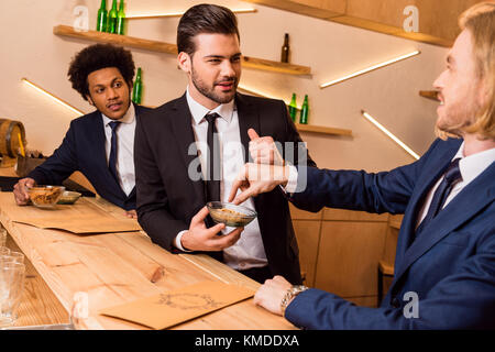 Imprenditori di mangiare uno spuntino nel bar Foto Stock