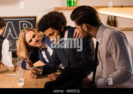 Imprenditori di bere whisky in bar Foto Stock