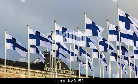 Helsinki, Finlandia - 6 dicembre 2017: installazione di un centinaio di bandiere per 100-anno-vecchio Finlandia a Helsinki la piazza del mercato con il presidential palac Foto Stock