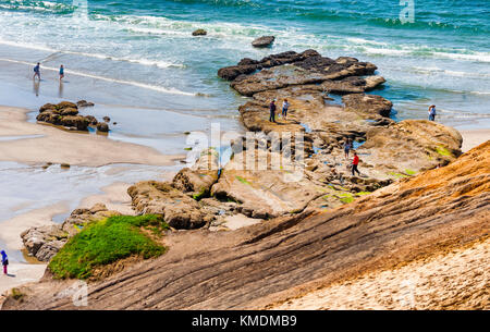 Persone esplorare il tidepools a Cape Kiwanda nella Città del Pacifico, Oregon. Foto Stock