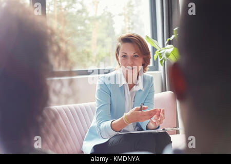 Terapista femminile che parla con la coppia in una sessione di terapia di coppia Foto Stock