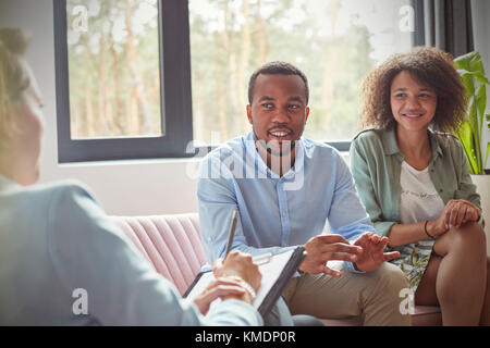 Coppia che ascolta la terapeuta femminile nella sessione di consulenza di terapia di coppie Foto Stock