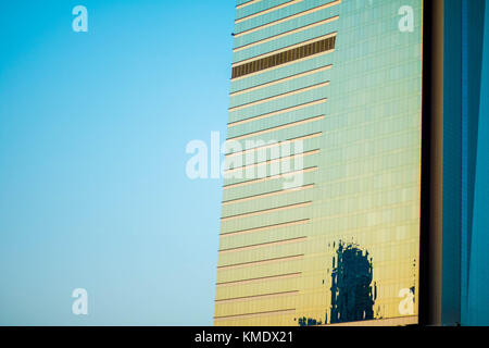La riflessione di un edificio distante su un altro edificio durante il tramonto a Dubai Foto Stock