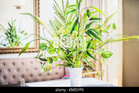 Bella e verde mazzo con varie foglie di piante in vaso a sfondo in camera. arredamento e decorazioni Foto Stock