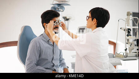 Donna facendo prova di occhio con all'ottico optometrista in vista dell'Occhio Clinica Foto Stock