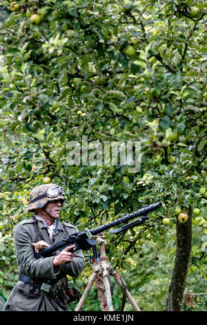Un WW2 Wehrmacht soldato con MG 34 fanteria mitragliatrice in un albero di mele Orchard Foto Stock