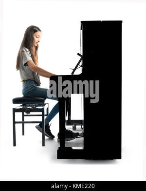 Teenage brunette girl e nero pianoforte verticale in studio Foto Stock