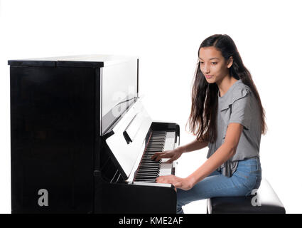 Teenage brunette girl e nero pianoforte verticale in studio Foto Stock