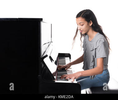 Teenage brunette girl e nero pianoforte verticale in studio Foto Stock