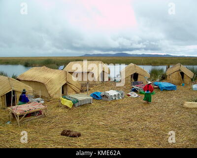 Puno, Perù - Gennaio 3, 2007: villaggio galleggiante del popolo Uros sul lago Titicaca. donne intorno a tavoli di artigianato in tipico abito. Foto Stock