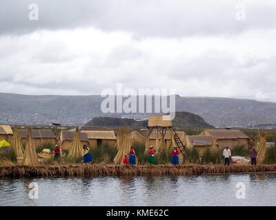 Puno, Perù - Gennaio 3, 2007: villaggio galleggiante del popolo Uros sul lago Titicaca. molti uomini e donne in tipico abito. Foto Stock