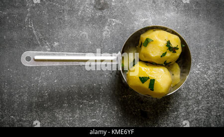 Cibo di patate . patate bollite nel piatto sul tavolo di pietra . vista superiore Foto Stock