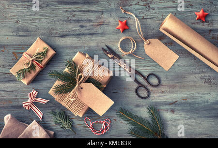 Realizzato a mano regali sul buio tavola in legno rustico con decorazioni di Natale. sfondo stagionale ripresa dall'alto. flat laico, vista dall'alto, immagine filtrata. ta Foto Stock