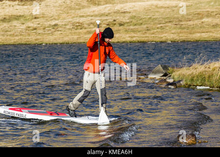 Stand Up Paddle boarder prendendo qualche rischio durante un freddo giorno di caduta vicino al Petit Saint Bernard passano tra Francia e Italia Foto Stock