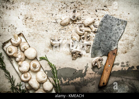 Funghi tagliati con spezie e una grande ascia di guerra. su sfondo rustico. Foto Stock