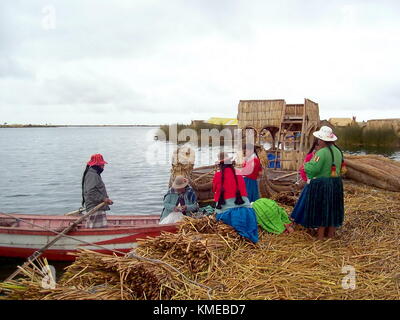 Puno, Perù, 3 gennaio 2007: uros donne acquistare le forniture provenienti da un mercato barca lungo il bordo di un'isola galleggiante, il lago Titicaca, Perù Foto Stock