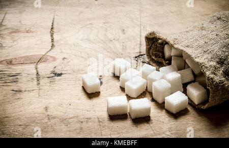 Bianco zucchero raffinato nel sacchetto. Sullo sfondo di legno. Foto Stock