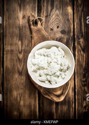 Freschi per la ricotta in una ciotola . su un tavolo di legno. Foto Stock