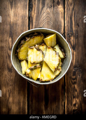 Fette di ananas in una pentola. su di un tavolo di legno. Foto Stock