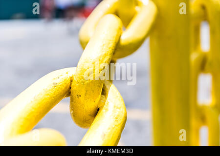 Macro closeup di metallo giallo dipinto di catena di grandi dimensioni sulla recinzione Foto Stock