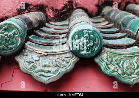 Impressione con decorazione brillante sul tetto del tempio in stile cinese, yin e yang piastrella, antica consistenza e roof top in rosso, ciano di Ho Chi Minh Foto Stock