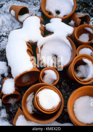 Pile di piccole, principalmente fatto a mano, terracotta fioriere lasciata fuori durante l'inverno. 23cm - 10 cm di diametro. Foto Stock