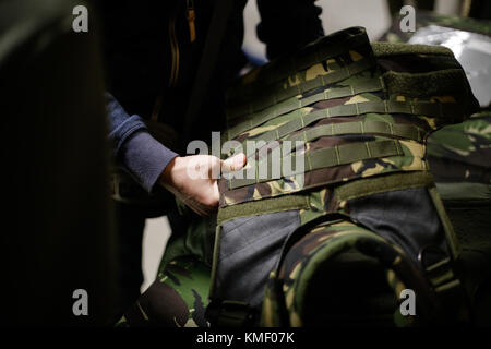 Un uomo sta ispezionando un antiproiettile giubbotto militare Foto Stock