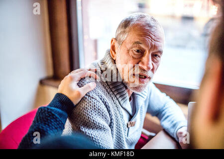 Padre senior e il suo giovane figlio in un cafe'. Foto Stock