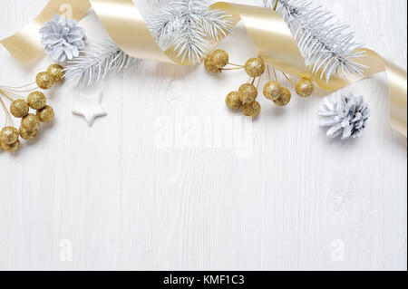 Mockup regalo di Natale oro nastro di prua e il cono ad albero, flatlay su un bianco sullo sfondo di legno, con posto per il testo Foto Stock