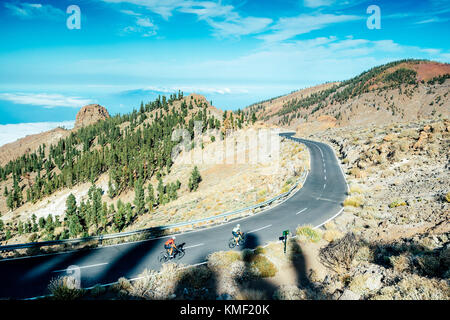 Due ciclisti a pedalare su strada di montagna,Parco Nazionale del Teide,Tenerife,Isole Canarie,Spagna Foto Stock