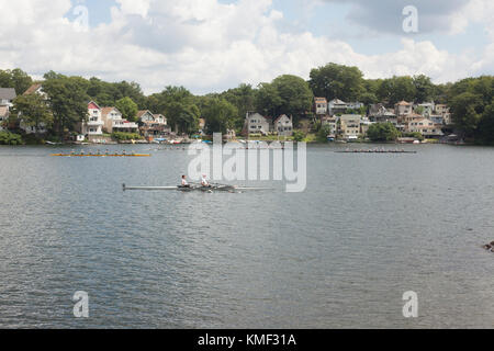 Equipaggio Barche racing in regata sul fiume con case e alberi su riverbank,Worcester, Massachusetts, STATI UNITI D'AMERICA Foto Stock