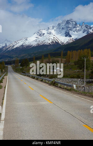 La Carretera Austral; strada famosa collegando remote città e villaggi nel nord della Patagonia cilena. sezione pavimentata in esecuzione passato delle montagne innevate. Foto Stock