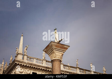 Vista ravvicinata di statue sulla sommità della Biblioteca Nazionale Marciana (pubblica libreria di riferimento) con lo sfondo del cielo a Venezia. Foto Stock