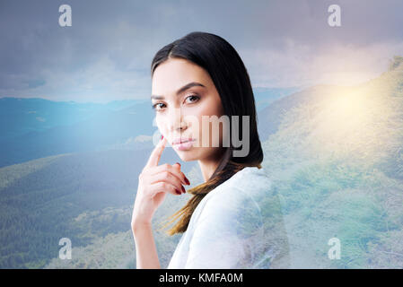Bella giovane donna di toccare il suo pulcino mentre pensando Foto Stock