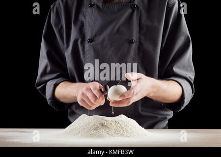 Primo piano della baker uovo di cracking per la pasta. Foto Stock