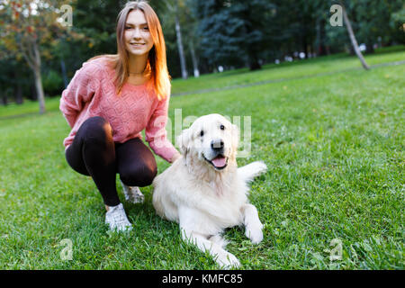 Immagine di brunette con labrador giacente sul prato in estate park Foto Stock