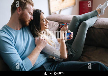 Coppia romantica a mangiare il gelato insieme e guardare la tv Foto Stock