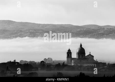 Vista della chiesa di Santa Maria degli Angeli (Assisi) contro uno sfondo di nebbia all'alba Foto Stock
