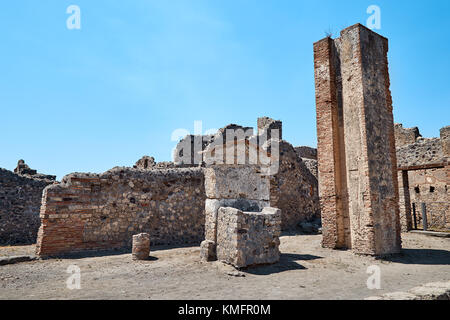 Resti delle mura di case, pozzi, torri e altre rovine di Pompei, Italia contro il cielo blu Foto Stock