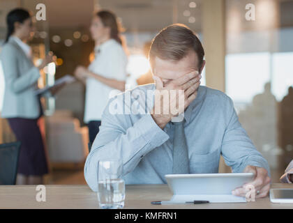 Stanco, ha sottolineato imprenditore utilizzando tavoletta digitale nella sala conferenze Foto Stock