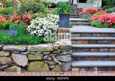 Muro di pietra naturale e bluestone passaggi su ingresso di casa. colorfull giardino, frenare ricorso. Foto Stock