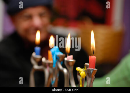 Hanukkah menorah sfondo. closeup di candele accese durante la celebrazione di Hanukkah, una festa ebraica, vecchio uomo guarda in background. Foto Stock